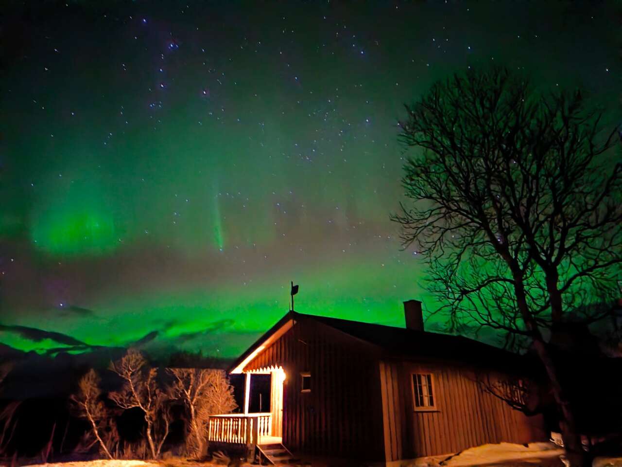 Aurores boréales au-dessus d’une cabane en Norvège