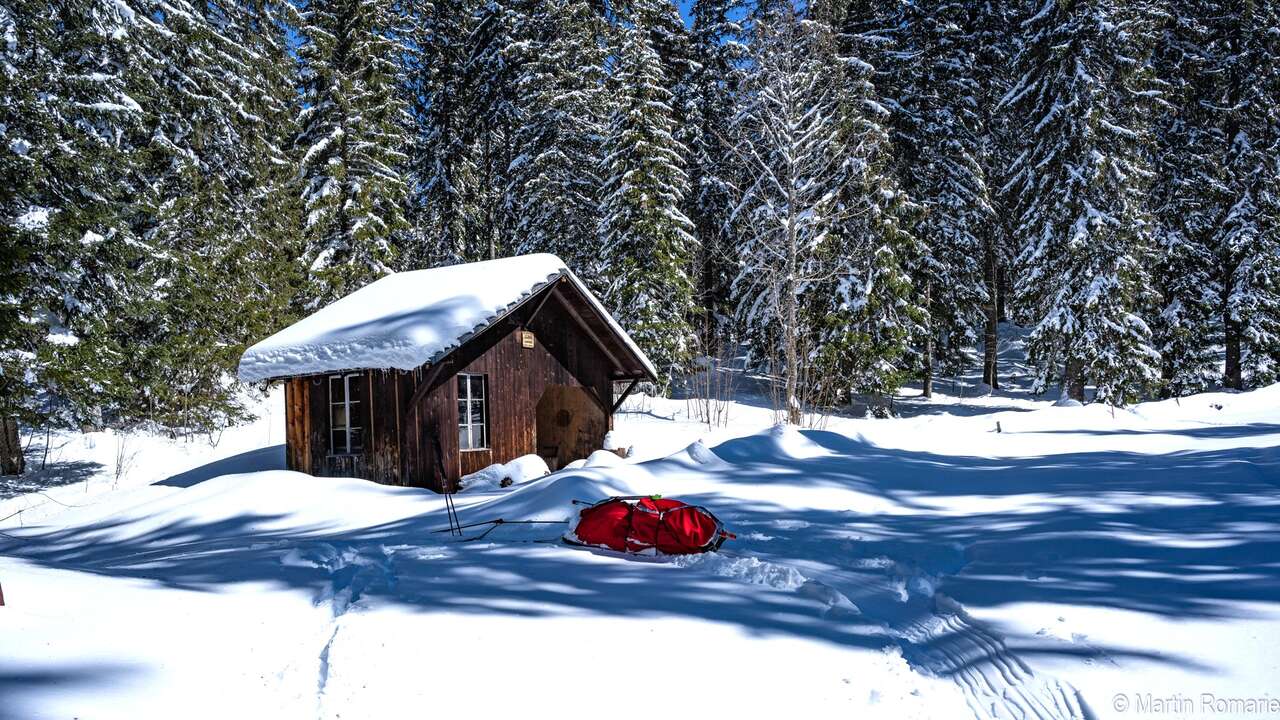 Cabane en bois dans la neige, forêt du Jura suisse en hiver