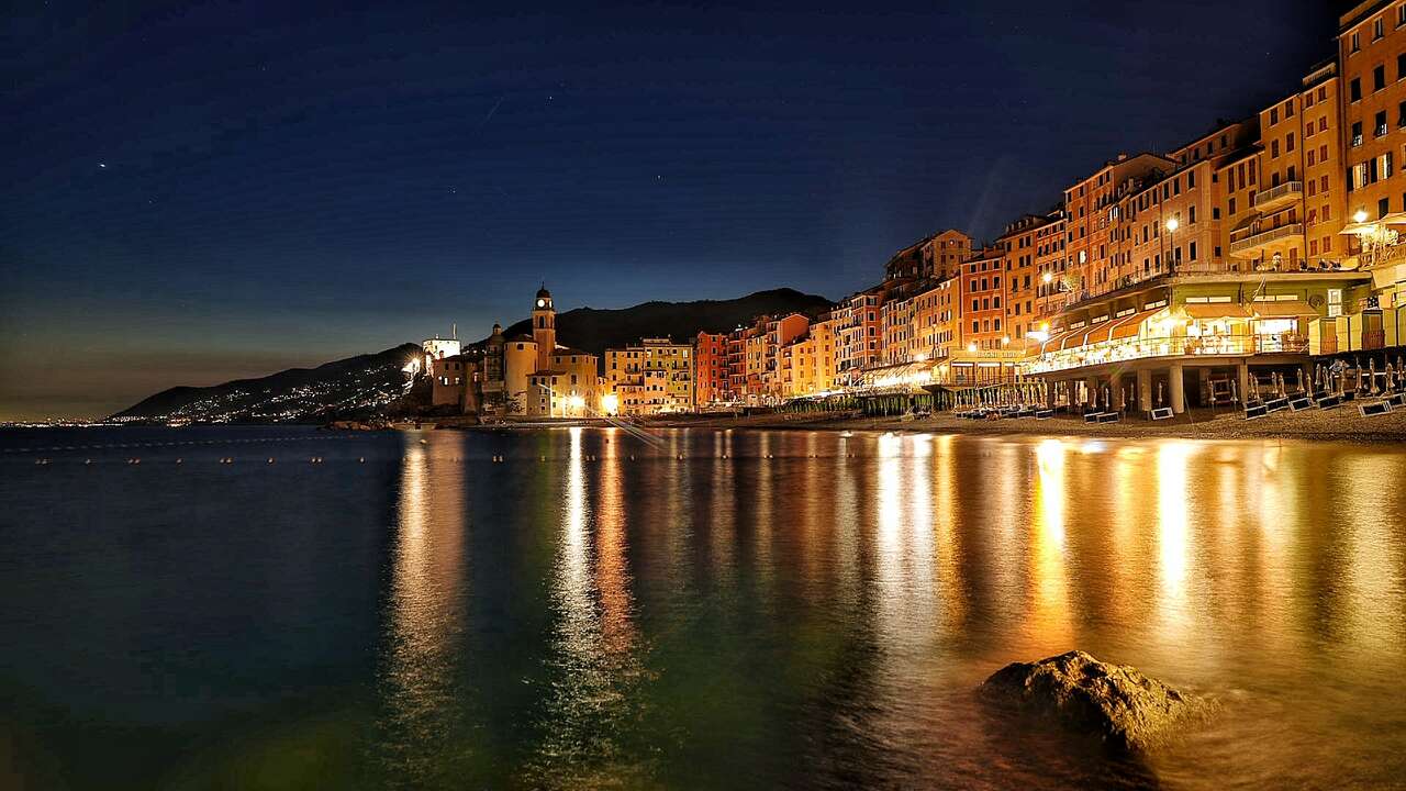 Camogli illuminé se reflétant dans la mer au crépuscule