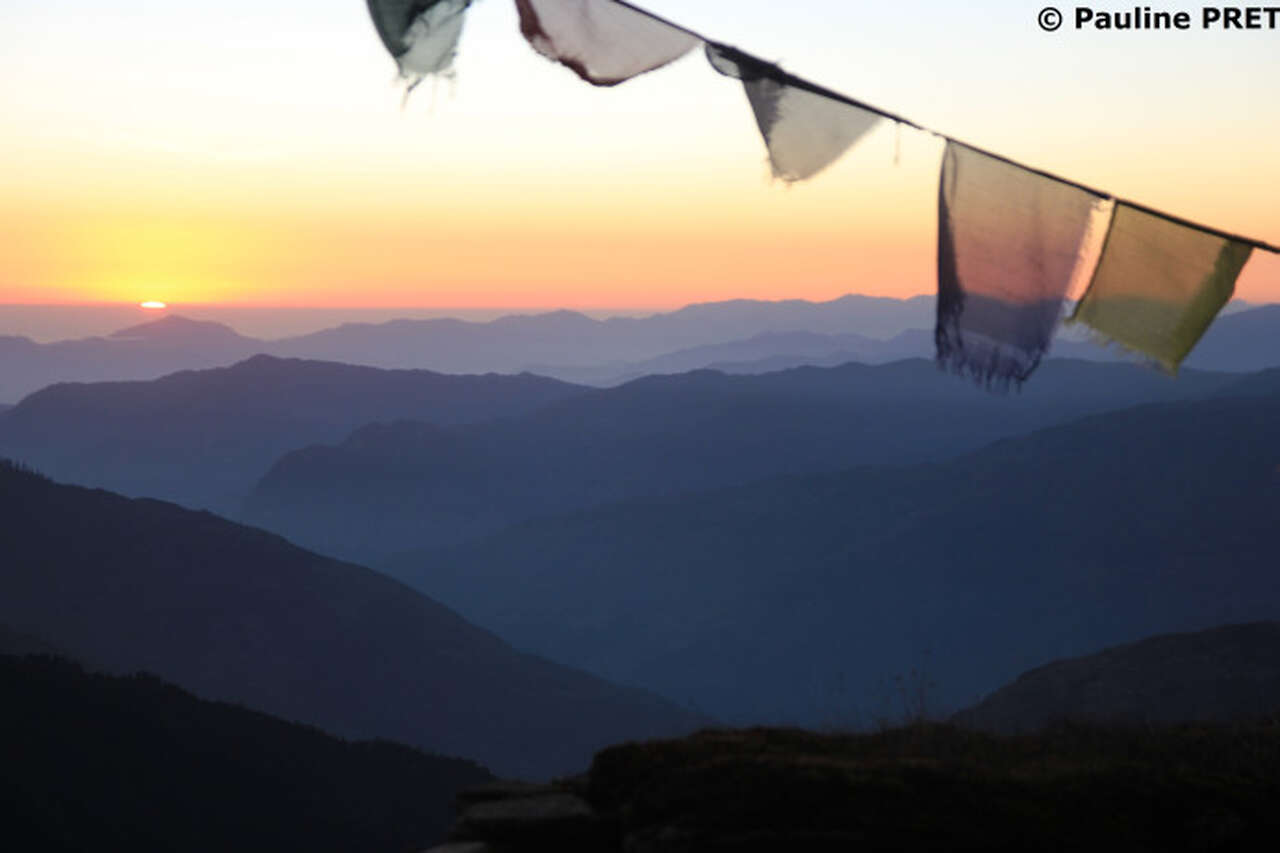 Drapeaux de prières bouddhistes au coucher du soleil dans les montagnes du Népal