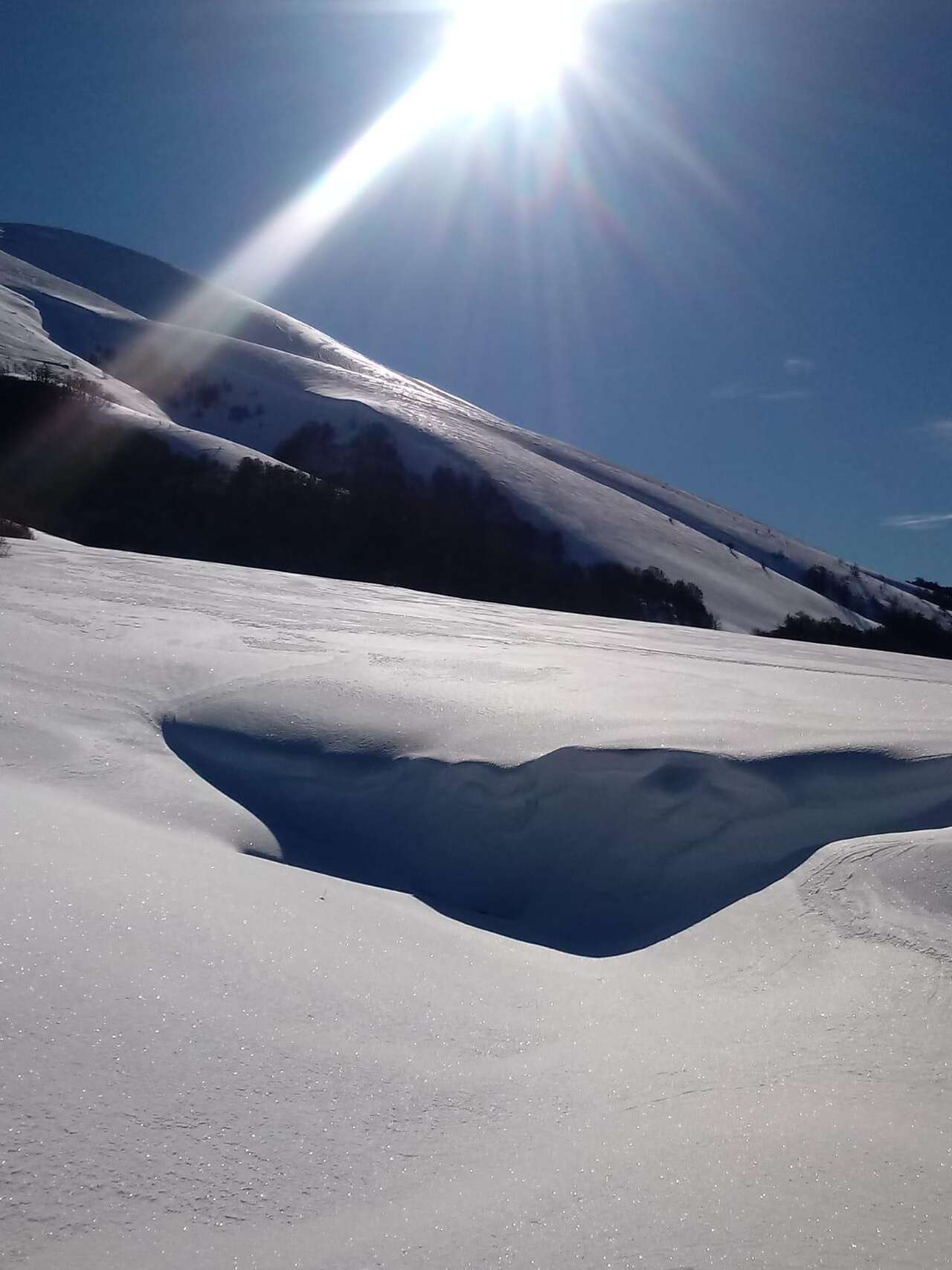 Lumière hivernale sur les crêtes enneigées des Abruzzes avec reflets scintillants sur la neige – séjour nature Amarok l’Esprit Nature