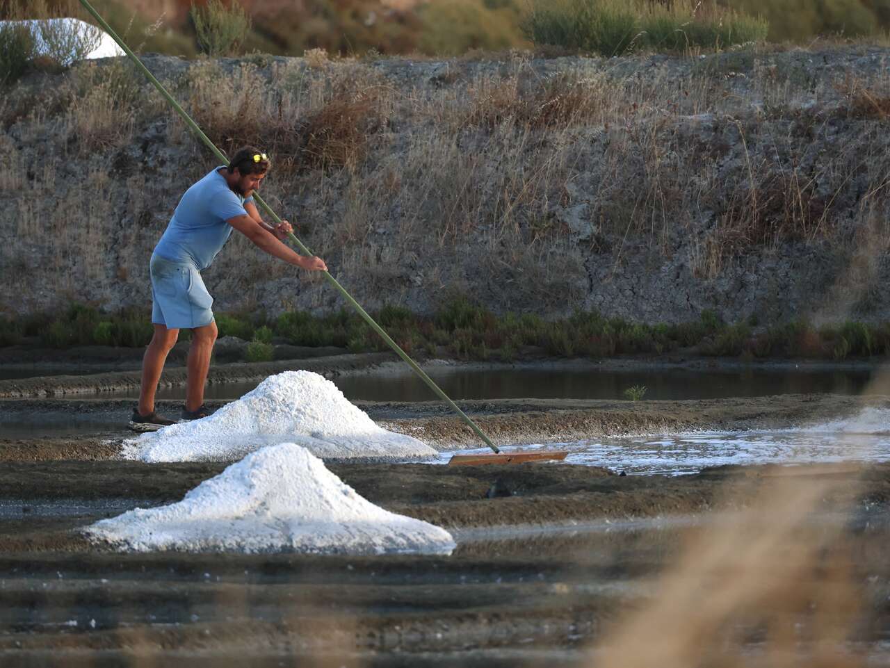Paludier récoltant le sel à la main dans les marais salants de Guérande