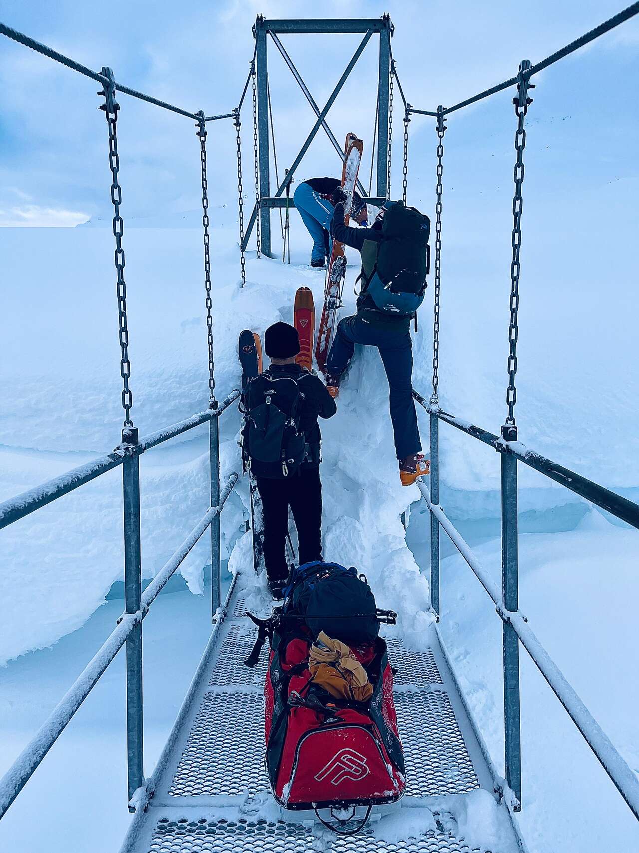 Traversée d'un pont enneigé à ski lors d'un raid dans le Nordland en Norvège