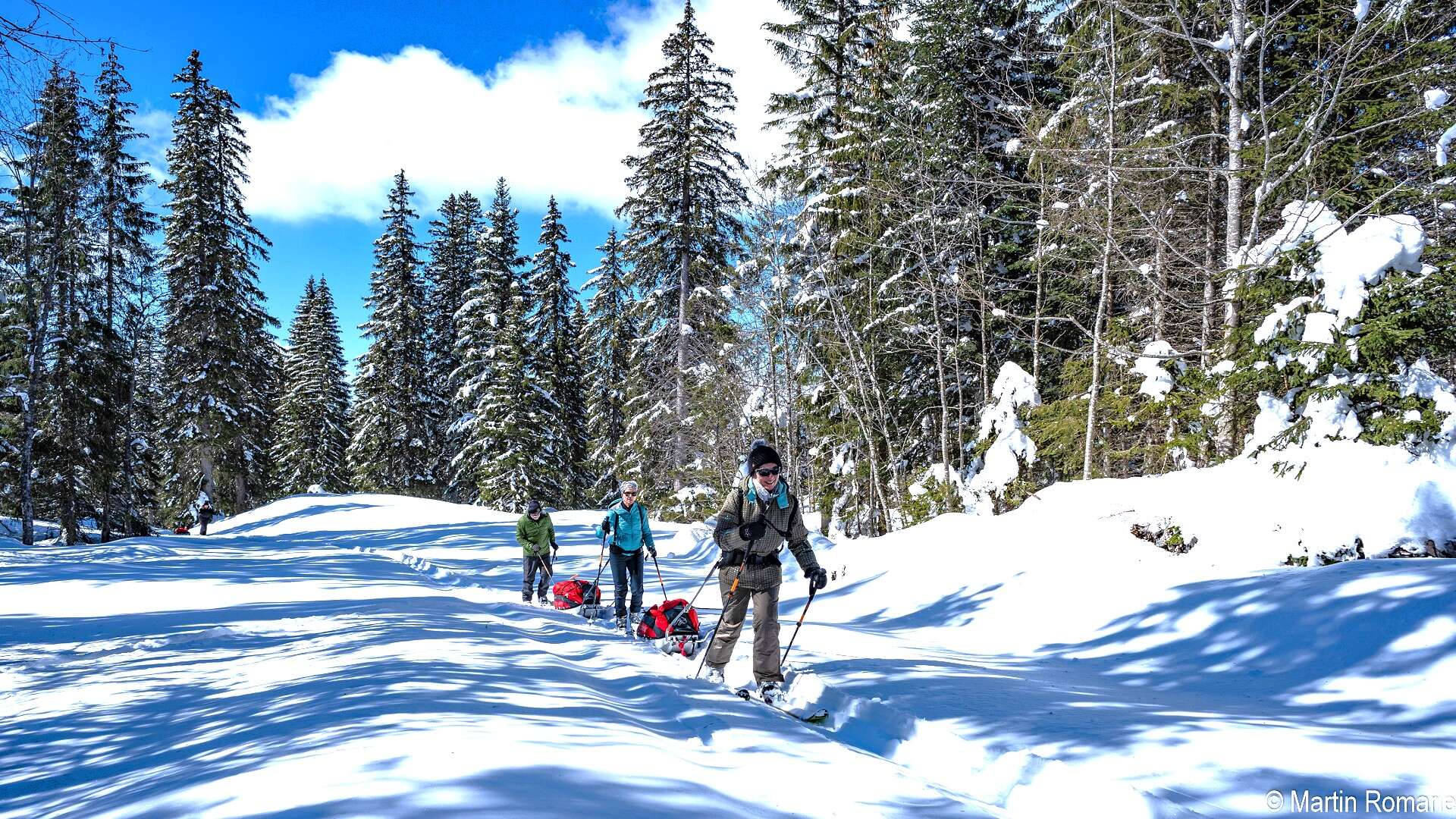 Week-end ski nordique dans le Jura suisse : immersion en forêt enneigée avec pulka © Martin Romarie Ski nordique dans le Jura suisse, randonneurs avec pulkas au cœur d’une forêt enneigée
