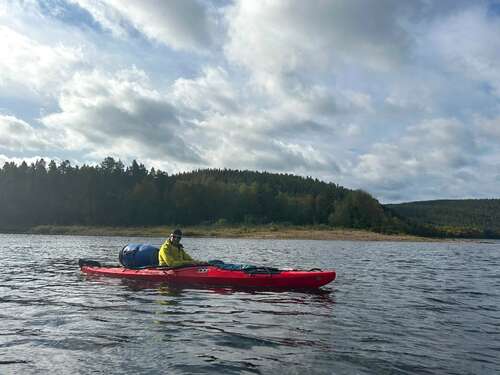 Kayakiste sur le lac Inari, en Finlande, au cœur des forêts boréales