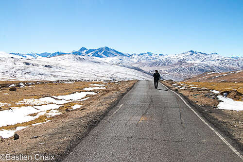 Paysage du Ladakh © Chaix Bastien Personne qui marche sur une route sur fond de montagnes enneigées